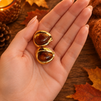 Boucles d'oreille gouttelettes sur main sans bagues, décor automnal