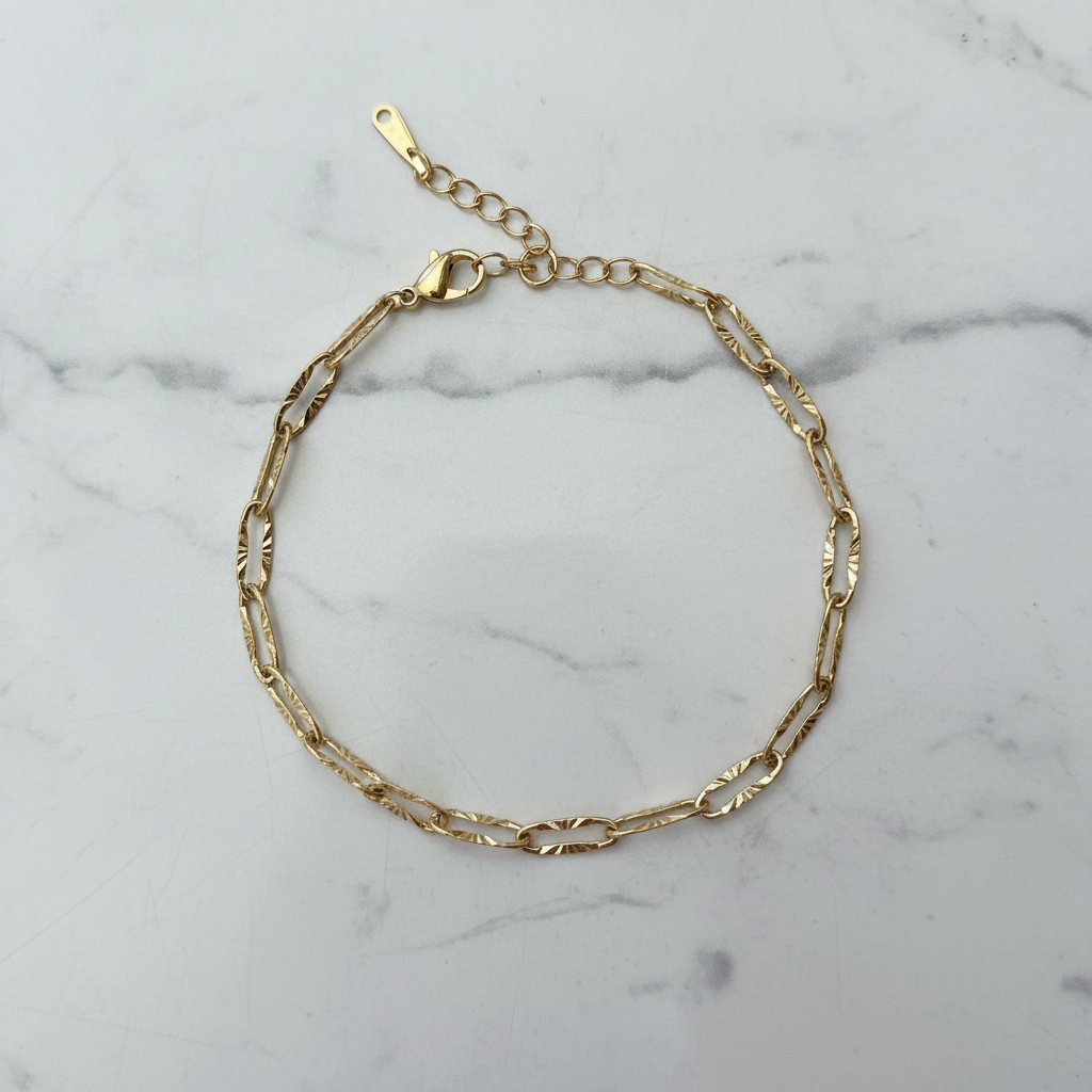 Bracelet chaîne dorée en cercle sur marbre
