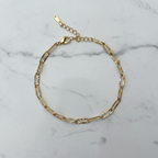 Bracelet chaîne dorée en cercle sur marbre
